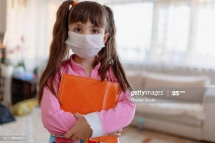 little girl wearing face mask at home